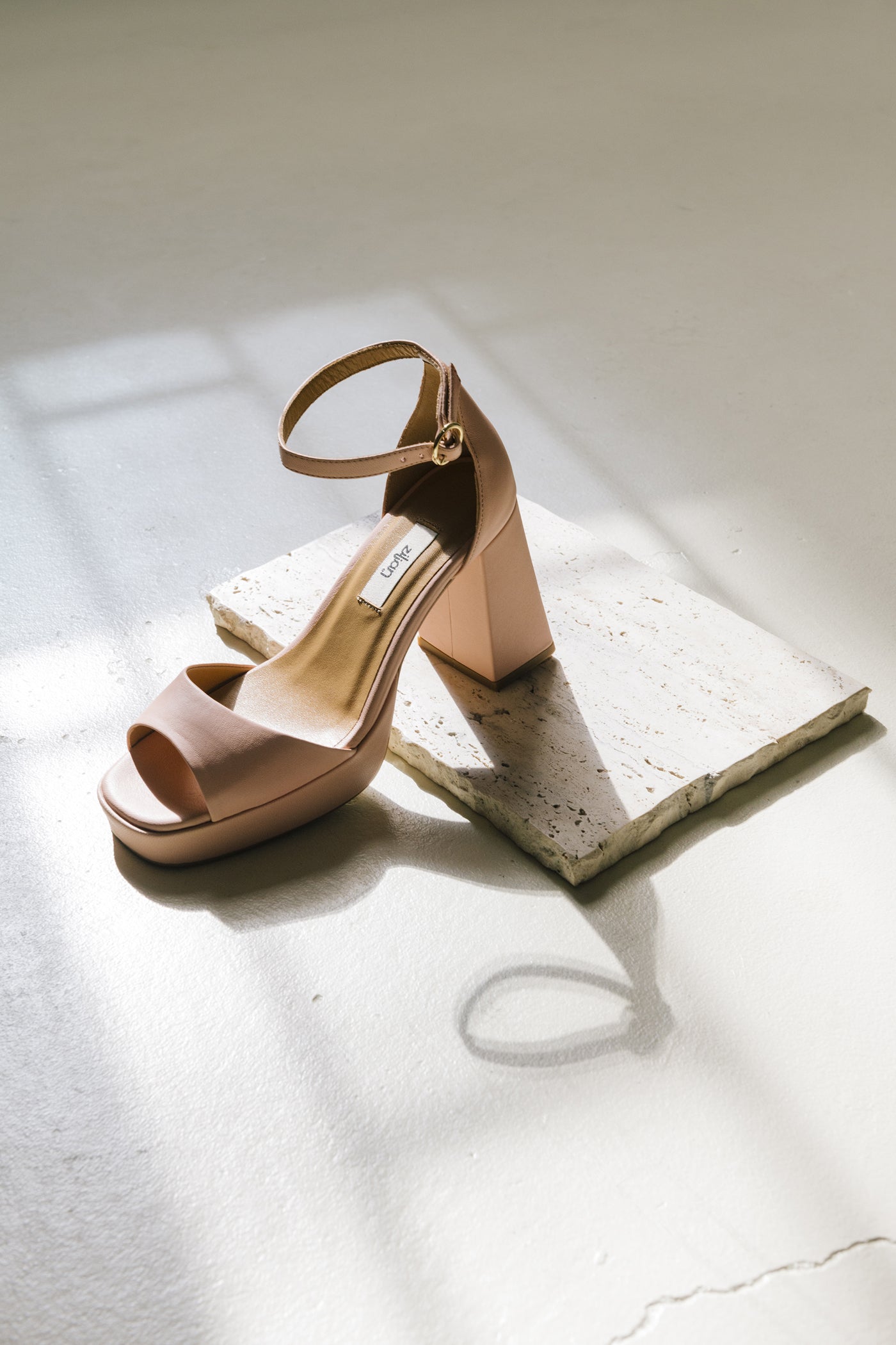 Sandálias de salto alto com fivela ajustável no tornozelo em pele nude.