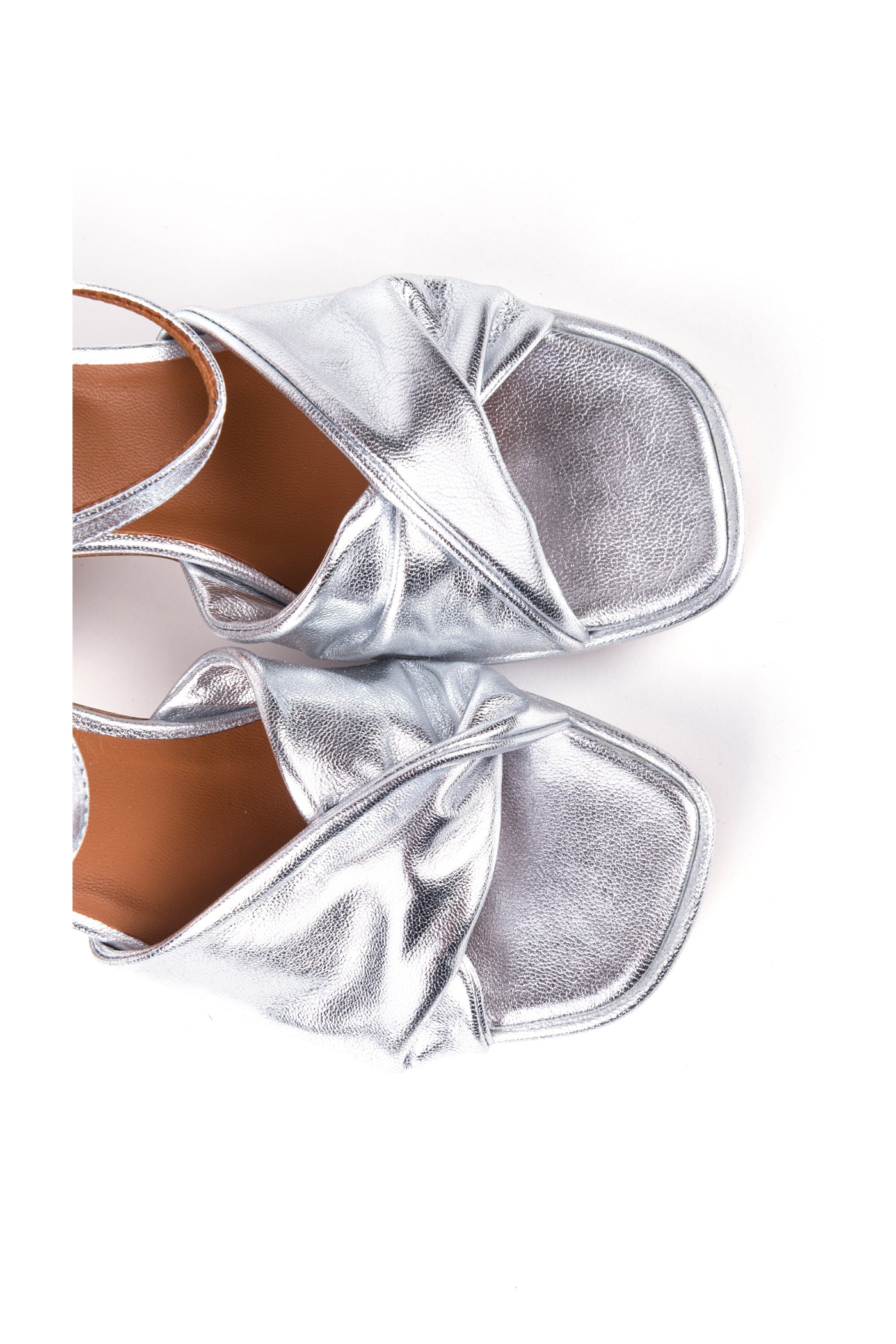 Vista de perfil das sandálias em pele metalizada champanhe e prata