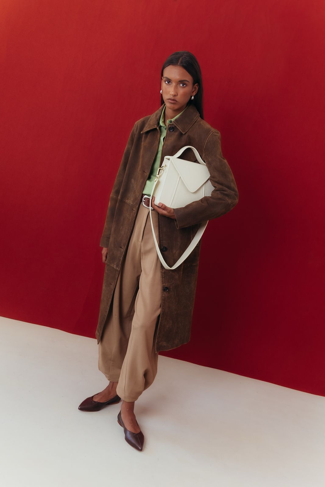 Mala envelope em pele off-white, fecho de íman em destaque