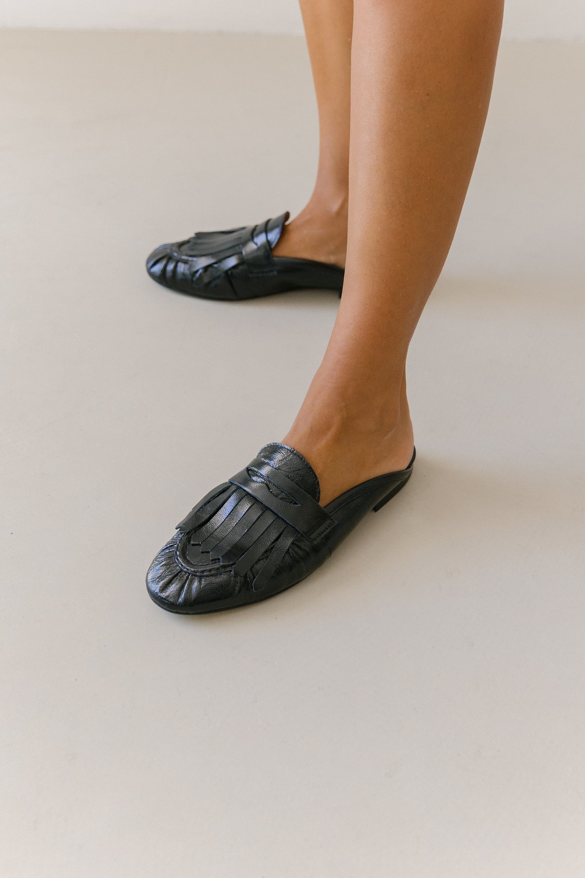 Mules rasas Zilian em pele envernizada preta, com salto de 1,5 cm