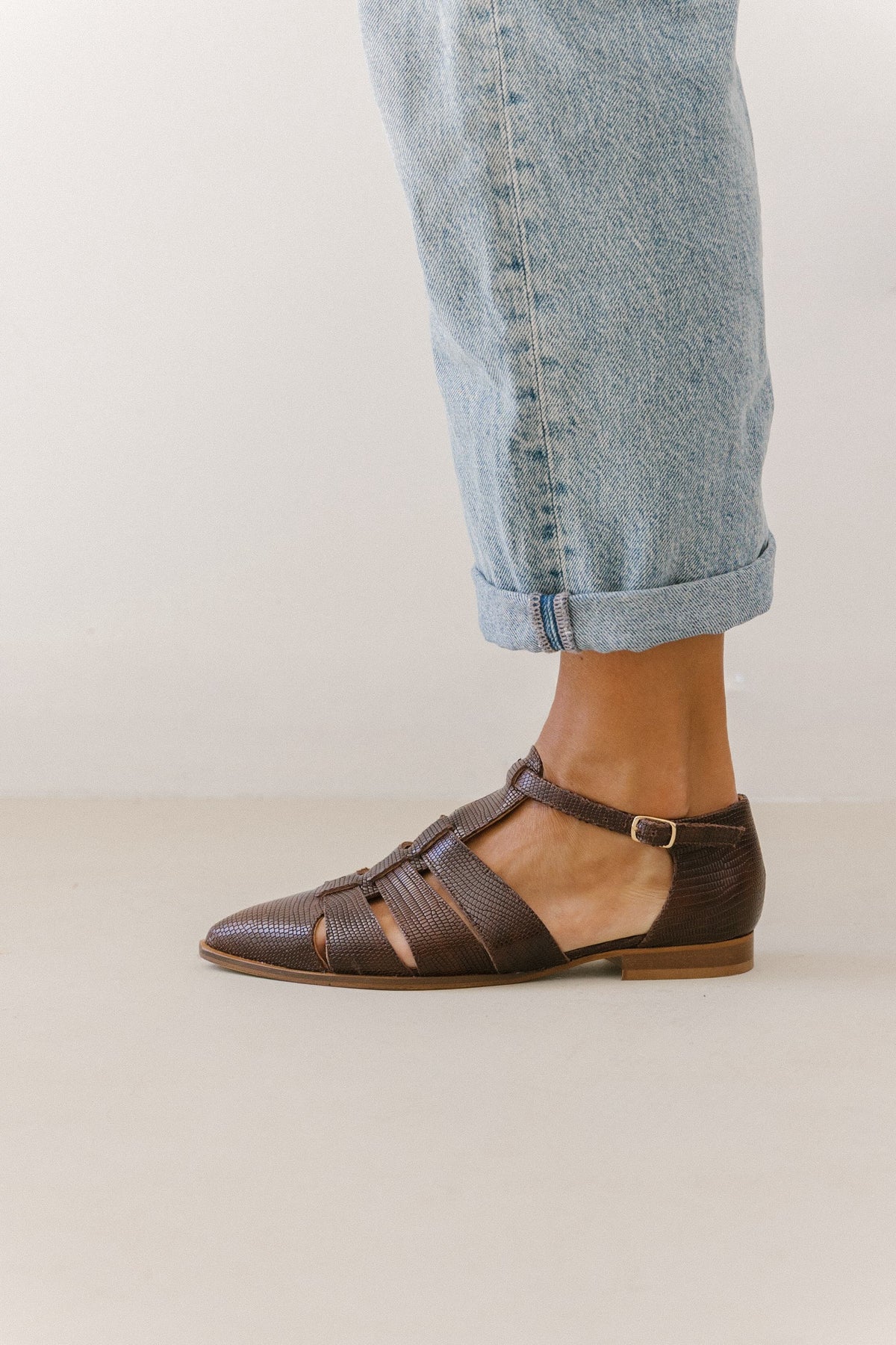 Sapatos fisherman castanhos Zilian com fivela dourada no tornozelo, usados com calças de ganga claras