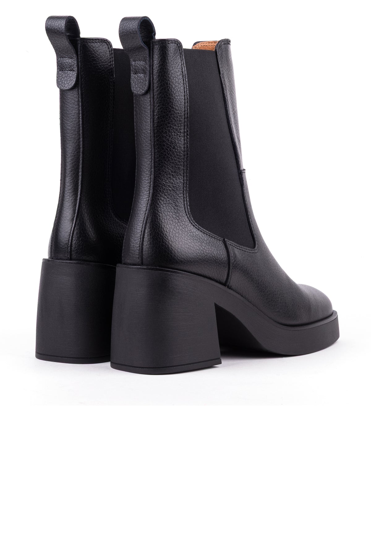 Par de botas chelsea pretas visto de trás, com as presilhas e o cano a meio da perna.