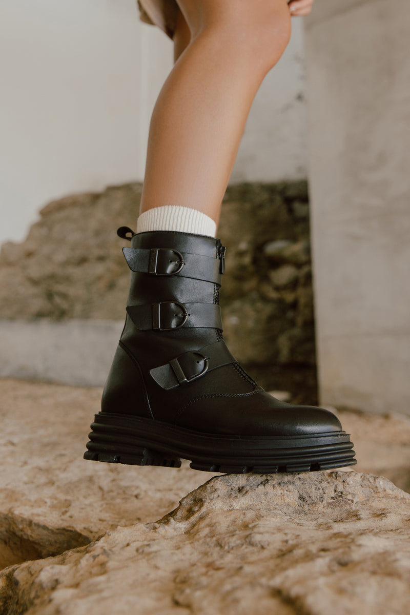 Botins estilo combat boot com fecho à frente em pele preta