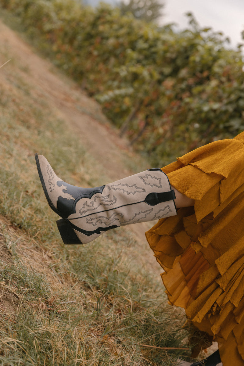 Botas texanas em pele preto e croute off-white com bordados no cano.