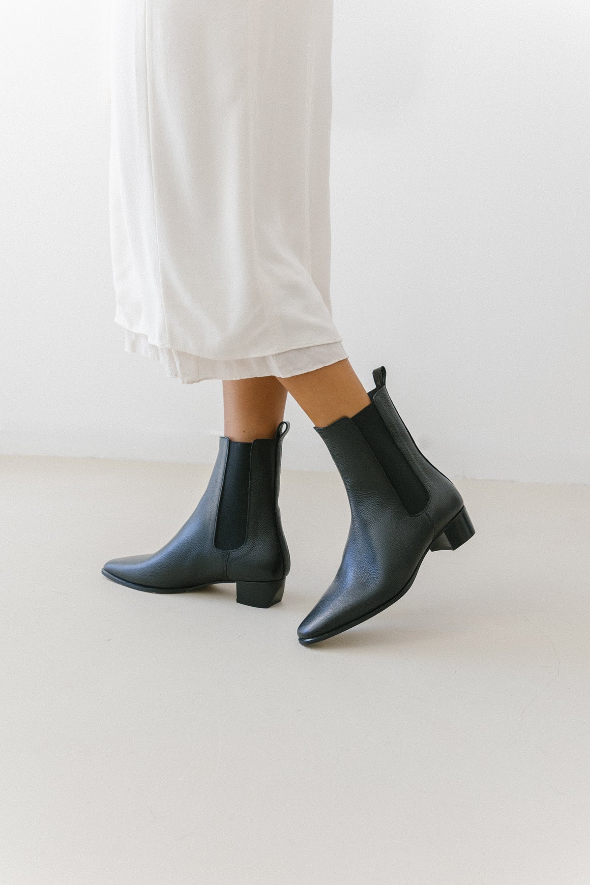 Botas chelsea em pele preta, com biqueira pontiaguda e salto de bloco de 4 cm.