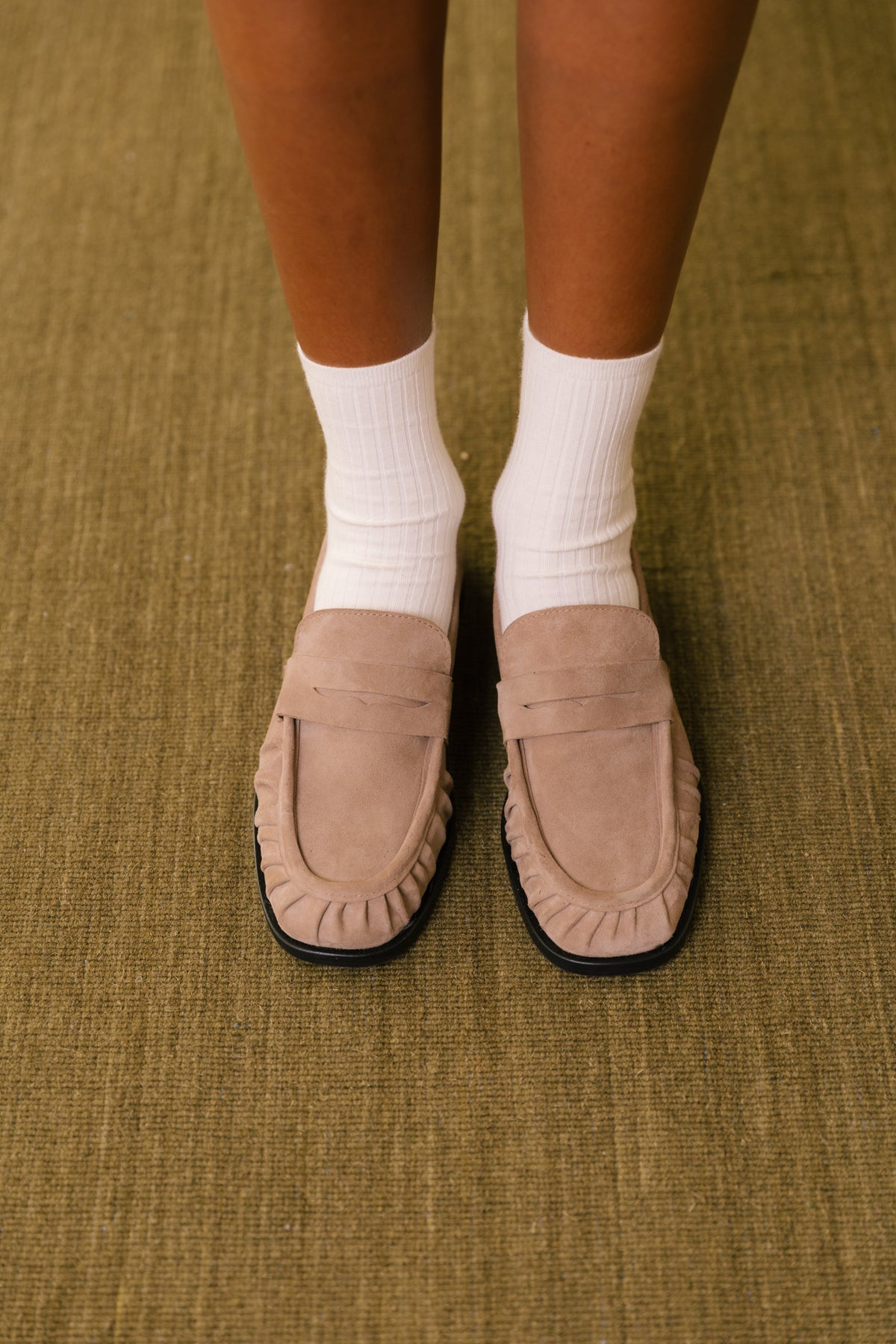 Loafers em camurça toupeira com biqueira franzida, usados com meias brancas