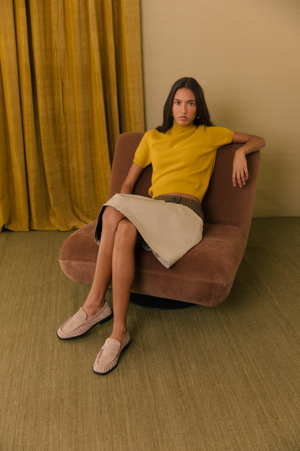 Loafers em camurça toupeira, usados com camisola mostarda e saia creme