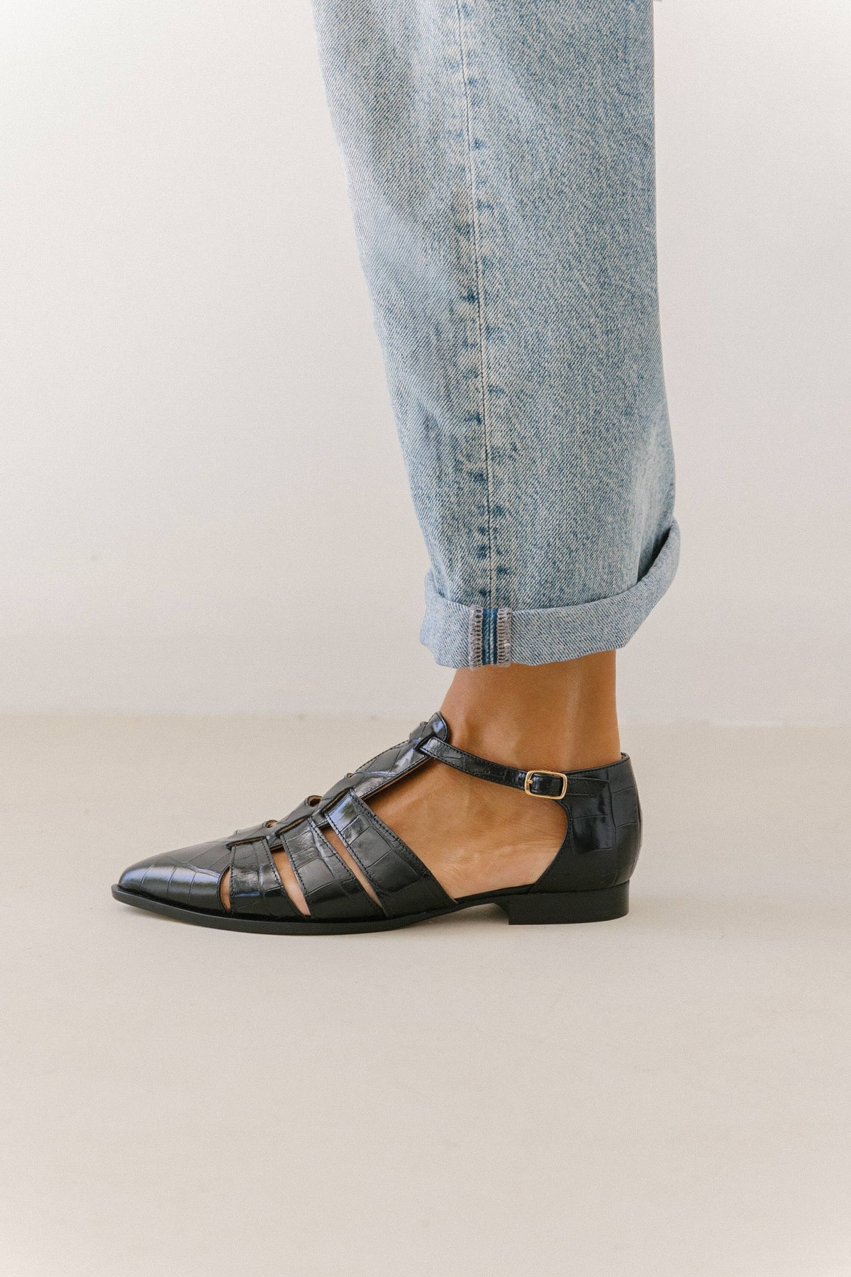Sapatos fisherman pretos em pele gravada, com a fivela do tornozelo em destaque