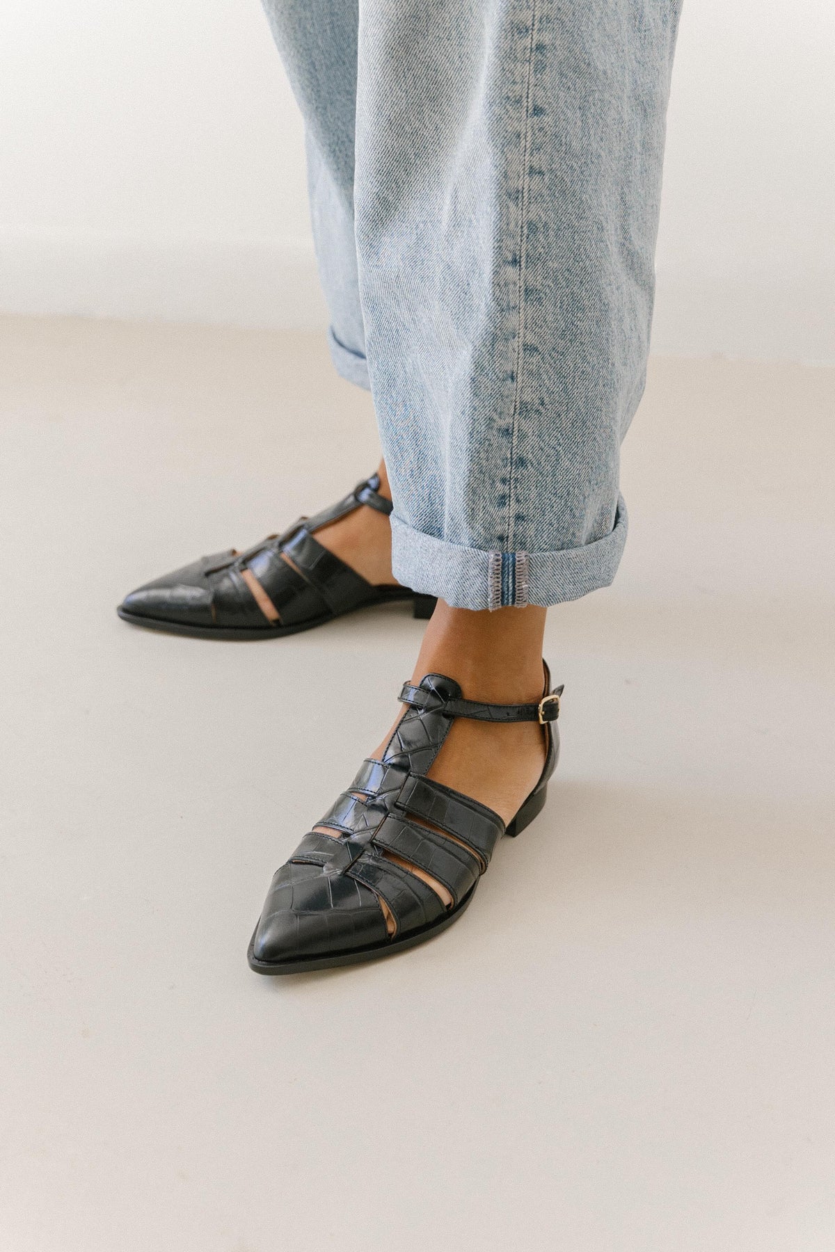 Sapatos rasos em pele gravada preta com efeito croco, com o salto baixo e a sola à vista