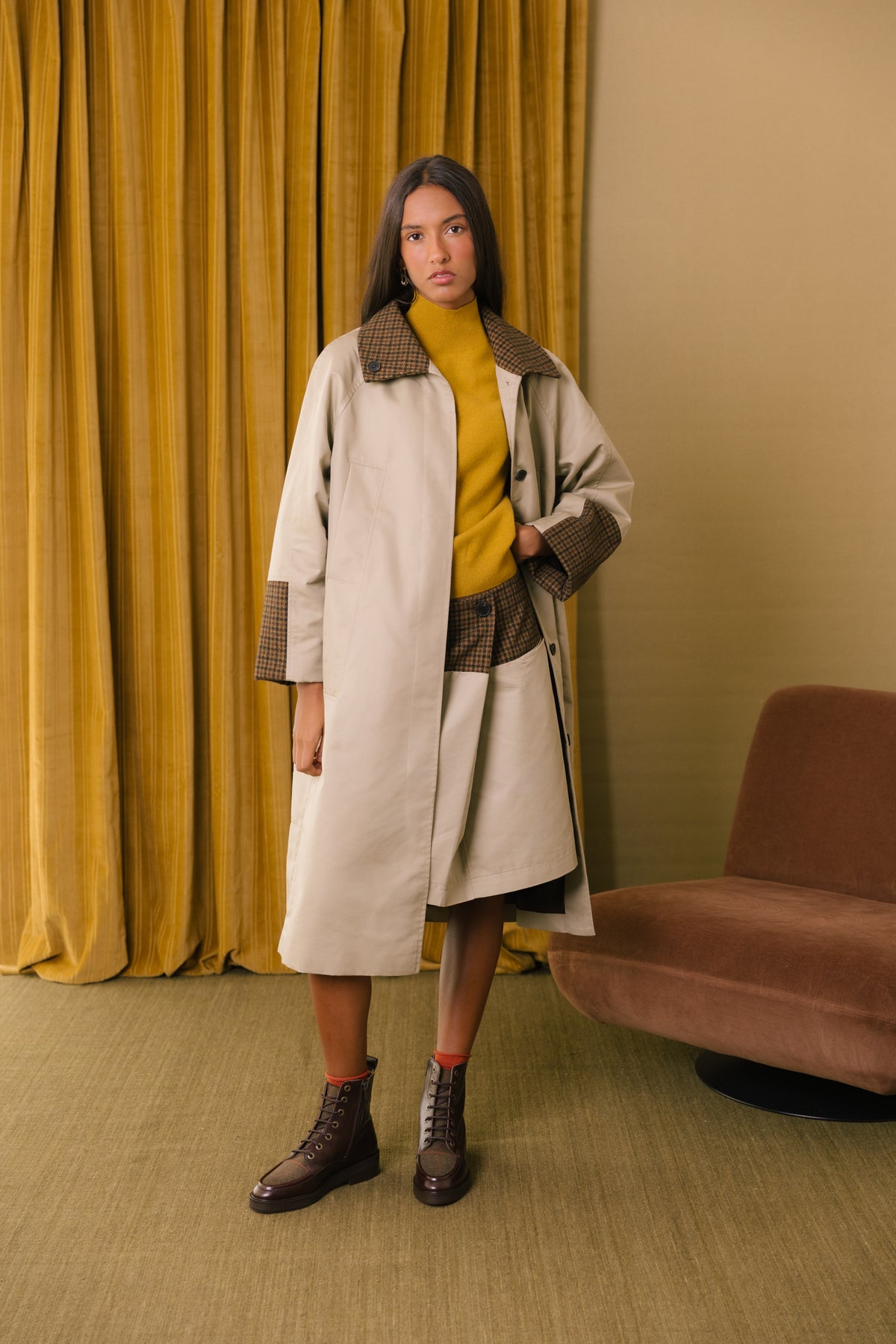 Botas castanhas em pele com recortes em tweed, usadas com gabardina comprida e meias laranja