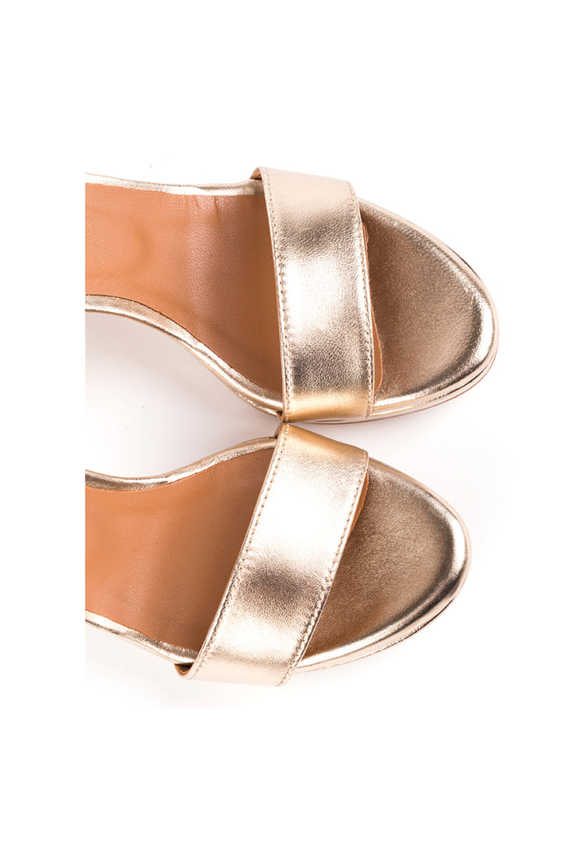 Sandálias de salto alto fino em pele metalizada dourada com pormenor de fivela no tornozelo. Compensados. REF: 600107